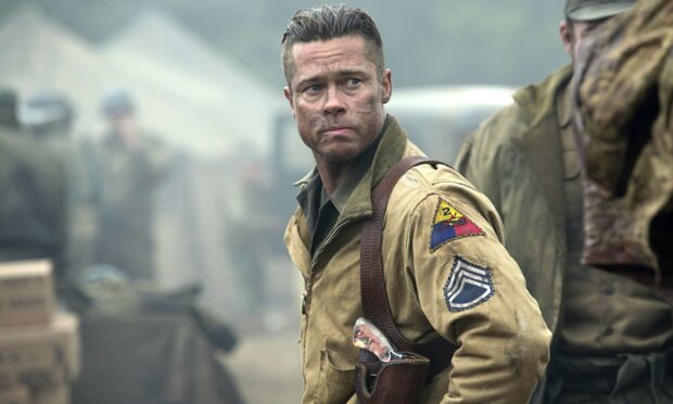 Brad Pitt looking serious in military uniform with scars on face in a war setting