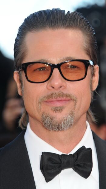 Brad Pitt wearing orange sunglasses and a black bow tie on a formal event