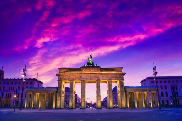 The Brandenburg Gate in Berlin stands illuminated under a vibrant purple and pink sky, HD Desktop Wallpaper