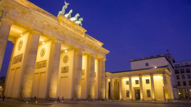 The Brandenburg Gate in Berlin is illuminated against a clear evening sky, 2K Desktop Wallpaper