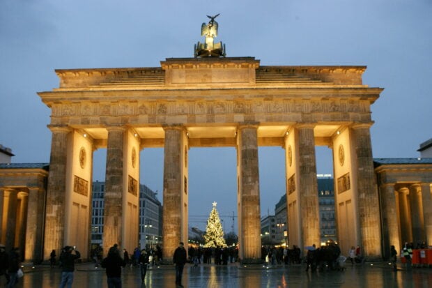 The Brandenburg Gate in Berlin is illuminated with a Christmas tree in the background during the evening, HD Desktop Wallpaper
