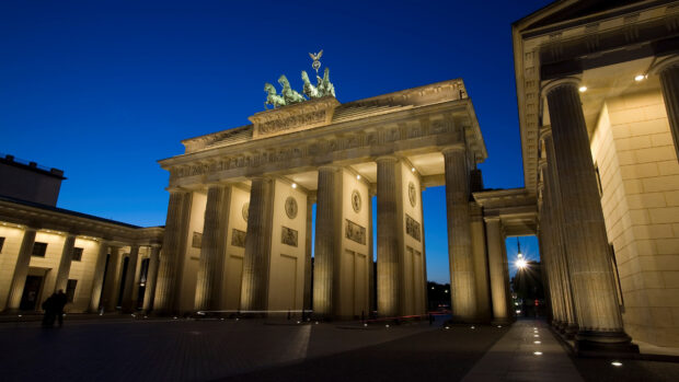 The Brandenburg Gate in Berlin is beautifully illuminated during dusk with a deep blue sky, 4K Desktop Wallpaper