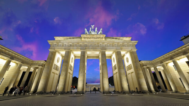 The Brandenburg Gate in Berlin is illuminated with a vibrant purple and blue sky at dusk, HD Desktop Wallpaper
