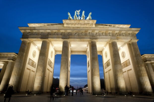 The Brandenburg Gate in Berlin is beautifully illuminated with a clear evening sky, 2K Desktop Wallpaper