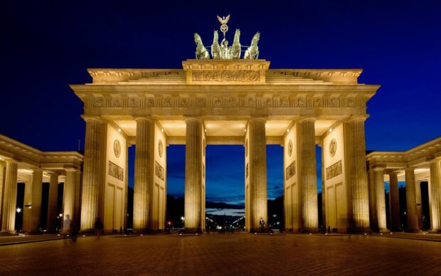 The Brandenburg Gate in Berlin is illuminated against a deep blue twilight sky, 2K Desktop Wallpaper