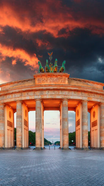 The Brandenburg Gate in Berlin stands under a fiery sunset sky, HD Phone Wallpaper