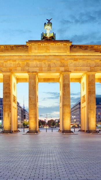 The Brandenburg Gate in Berlin is beautifully lit during twilight with clear skies, HD Phone Wallpaper