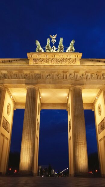 The Brandenburg Gate in Berlin is illuminated against a dark blue evening sky, HD Mobile Wallpaper