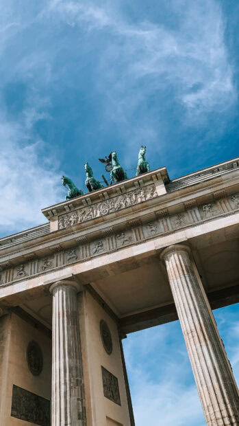 The Brandenburg Gate in Berlin stands tall under a cloudy blue sky, 4K Mobile Wallpaper