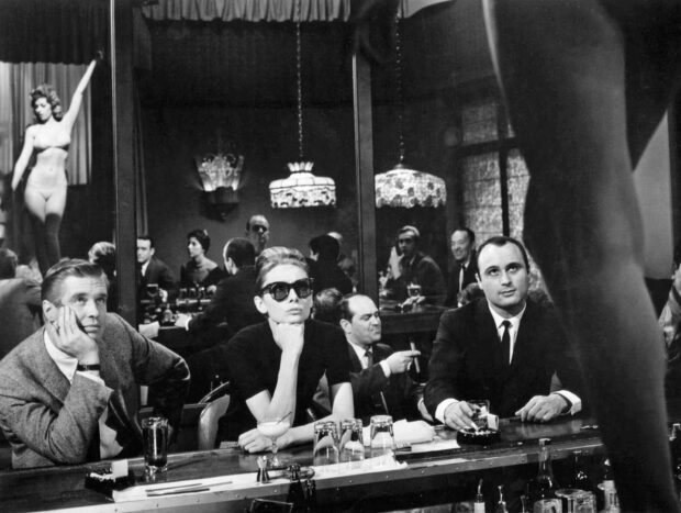 A classic scene featuring Breakfast At Tiffanys characters sitting at a bar in black and white vintage style