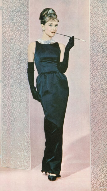 Audrey Hepburn wearing a classic black dress from Breakfast At Tiffanys film posing elegantly