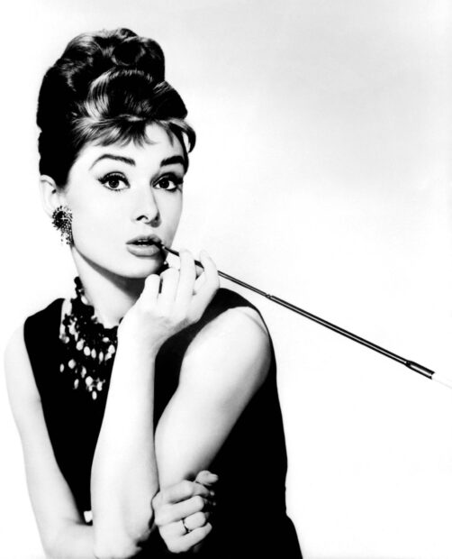 Iconic Breakfast At Tiffanys scene featuring a stylish woman holding a long cigarette holder