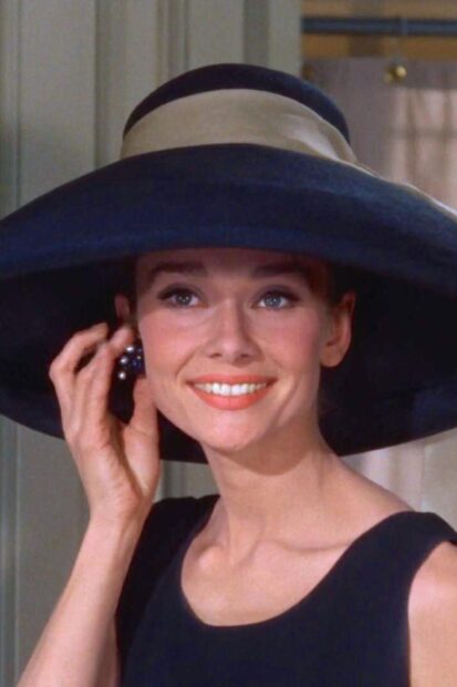 Woman wearing a large hat and elegant earrings in Breakfast At Tiffanys scene