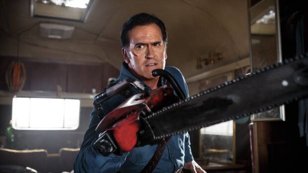 Bruce Campbell is holding a chainsaw with determination inside a dimly lit room, 4K Desktop Wallpaper