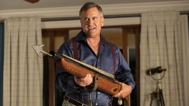 Bruce Campbell Wallpapers shows a man holding an old fashioned rifle indoors with curtains in the background, HD Desktop Wallpaper