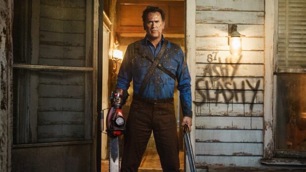 Bruce Campbell stands ready with a chainsaw and shotgun covered in dirt, HD Desktop Wallpaper