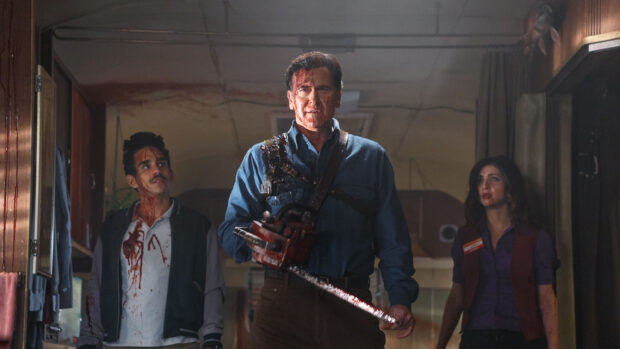 Bruce Campbell holding a chainsaw covered in blood with two companions behind him, 2K Desktop Wallpaper