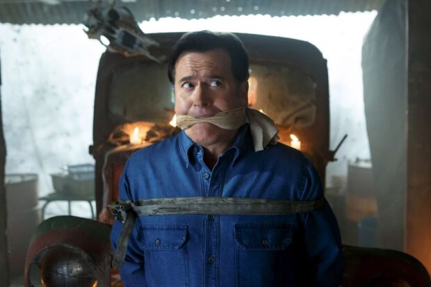 Bruce Campbell is tied and gagged in a dimly lit room with candles, HD Desktop Wallpaper