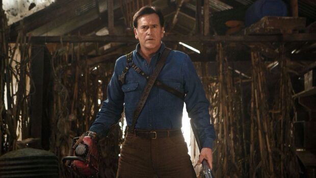 Bruce Campbell wallpapers shows him holding a chainsaw and shotgun in a rustic barn, HD Desktop Wallpaper