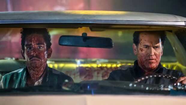 Two men covered in blood sit inside a car looking tense in a Bruce Campbell scene, HD Desktop Wallpaper