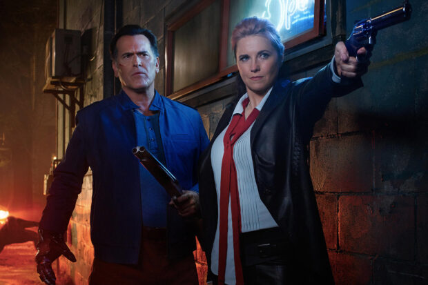 Bruce Campbell poses with a female partner holding weapons in a dark alley, HD Desktop Wallpaper