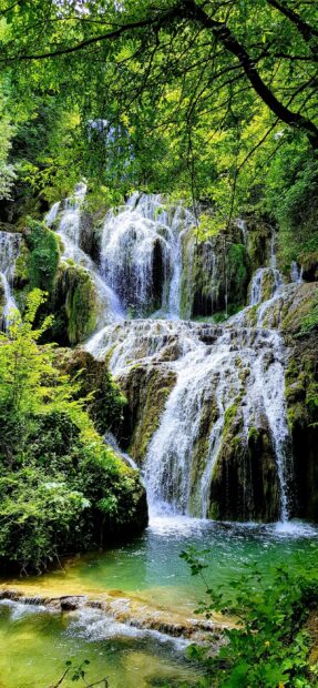 A beautiful waterfall in Bulgaria surrounded by lush green trees and clear water, 2K Mobile Wallpaper