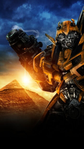 Bumblebee robot from Transformers stands in front of an Egyptian pyramid at sunset
