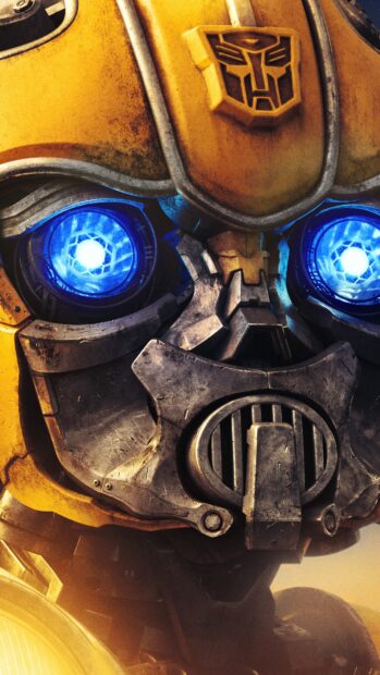 Close up of Bumblebee Transformers robot face with glowing blue eyes and battle worn armor