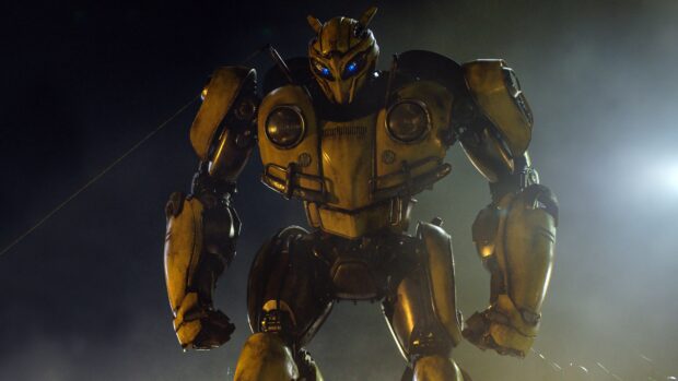 A high quality wallpaper featuring the yellow robot Bumblebee with glowing blue eyes standing in a dark misty environment