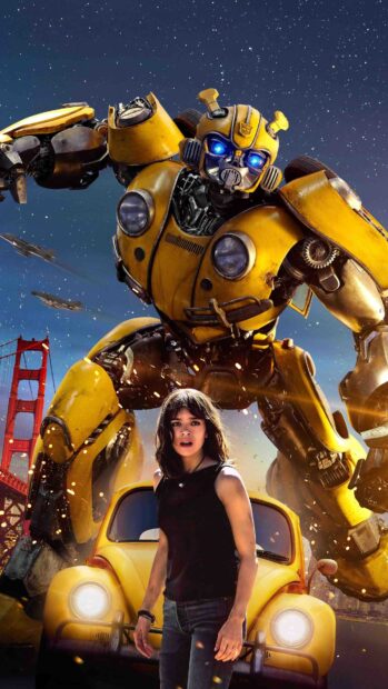 A girl stands in front of the yellow robot Bumblebee and a classic car under a starry sky