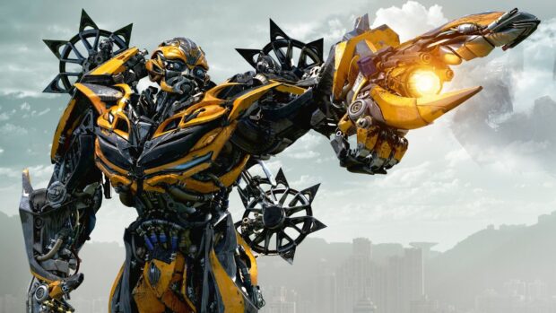 A detailed yellow robot robot from Transformers stands ready to fight against a cloudy city backdrop