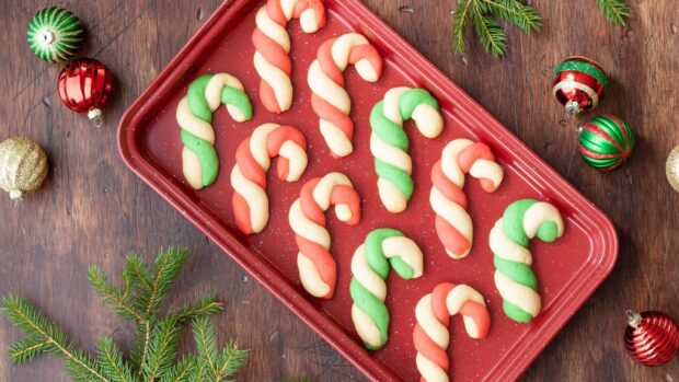 Christmas candy cane cookies arranged on a red baking tray