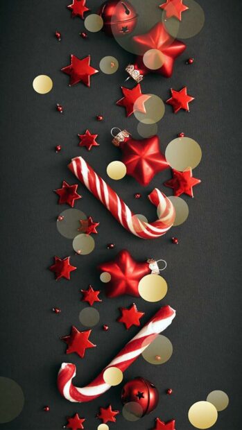 Red candy cane and star decorations on a dark surface with bokeh effects