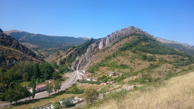 A scenic view of the Cantabrian Mountains with winding roads and green vegetation