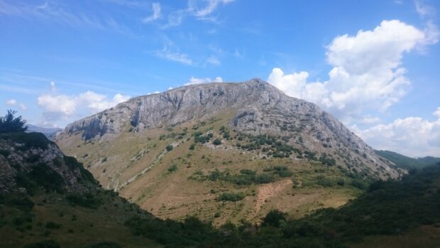 A rocky Cantabrian Mountains landscape under a bright blue sky with scattered clouds
