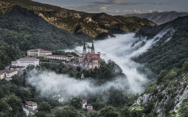 Historic church surrounded by Cantabrian Mountains and morning fog