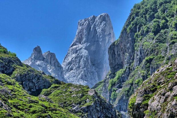 Rugged Cantabrian Mountains with rocky peaks and green slopes under clear blue sky
