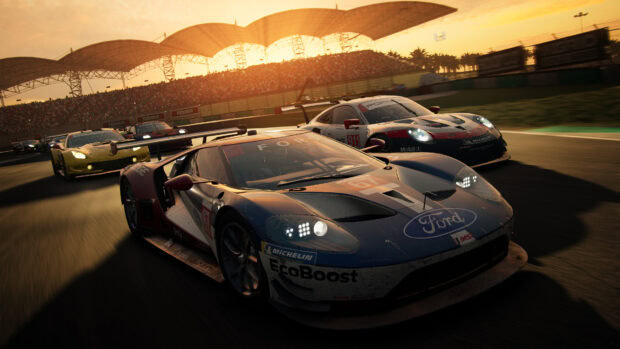 Ford race car leading a group of race cars on a track during sunset