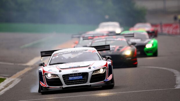 Audi leading the car race on the track with other race cars behind in high speed