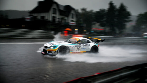 A car race skidding through wet track sprays water in a thrilling race
