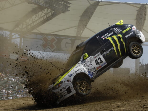 A car race vehicle kicking up dirt during an intense rally event