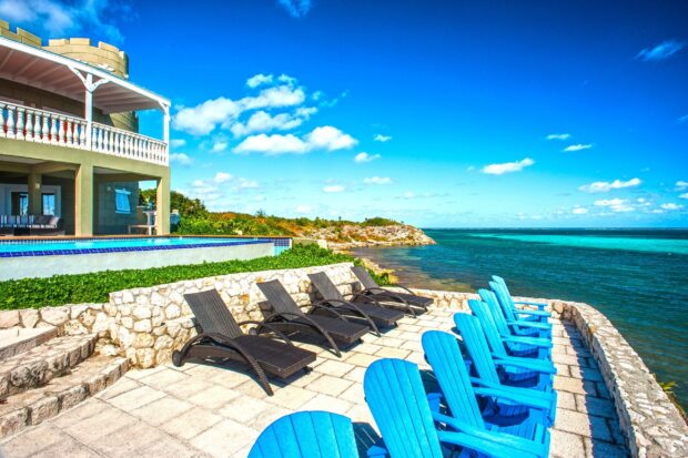 Relaxing patio with blue and black chairs overlooking the ocean in Cayman Islands