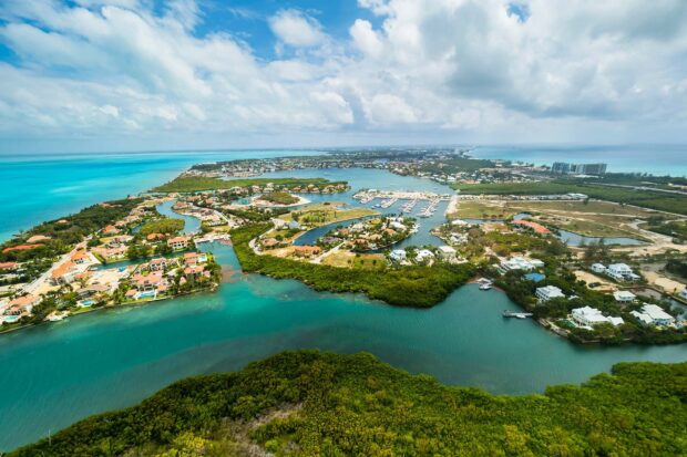 Aerial view of Cayman Islands coastline with turquoise water and lush greenery