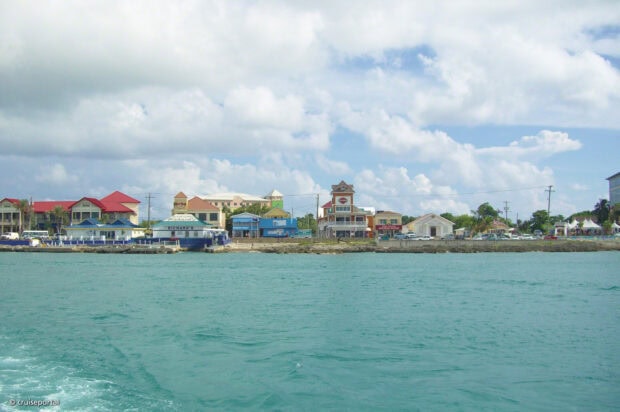 Colorful buildings along the coastline of Cayman Islands under a cloudy sky