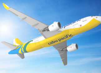 Colorful Cebu Pacific airplane flying in clear blue sky with sun flare, bright yellow, blue, and green livery, showcasing airline branding and jet engines.
