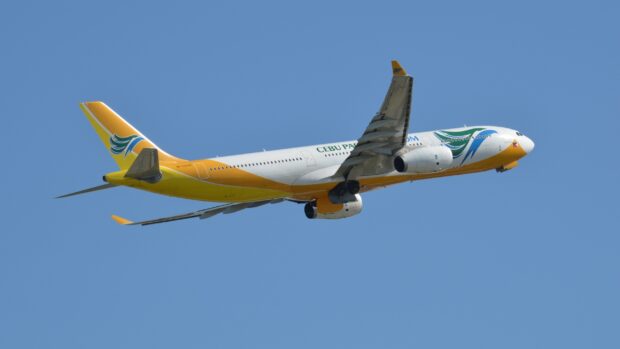 A Cebu Pacific Air airplane is flying against a clear blue sky, 2K Desktop Wallpaper