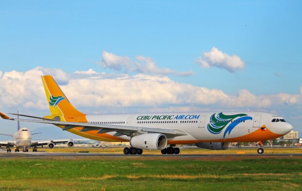 A Cebu Pacific Air airplane is parked on a runway under a clear sky, HD Desktop Wallpaper