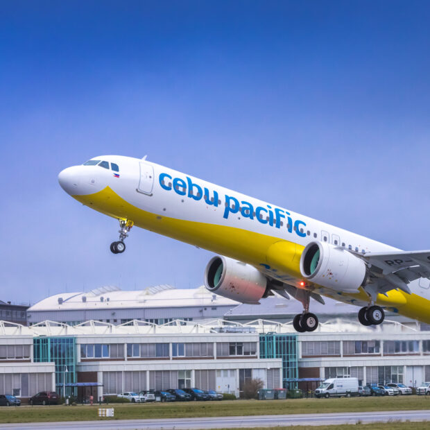 A Cebu Pacific Air airplane is taking off over an airport runway under a clear sky, HD Desktop Wallpaper