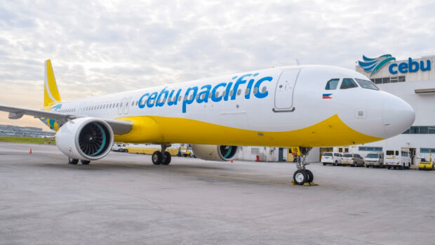 A Cebu Pacific Air plane is parked on the airport runway near the terminal, HD Desktop Wallpaper