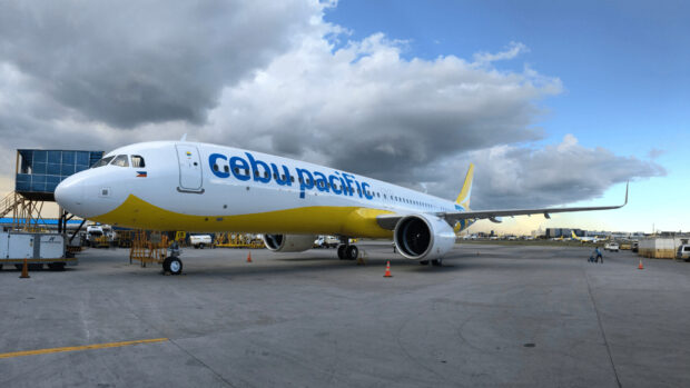 A Cebu Pacific Air plane is parked on the airport runway under a dramatic cloudy sky, HD Desktop Wallpaper